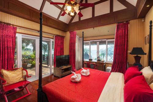 a bedroom with a red bed with two animals on it at Gala Beachfront Villa in Pattaya South