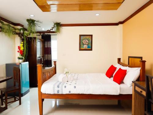 a bedroom with a bed with red and white pillows at AIRBEST Explore Chiang Rai Hotel in Chiang Rai