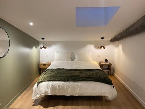 een slaapkamer met een groot wit bed in een kamer bij Maison ARBO in Montagne