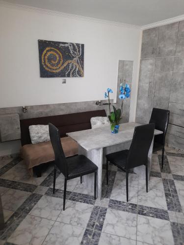 a dining room with a table and chairs and a couch at Villa Markos in Perissa