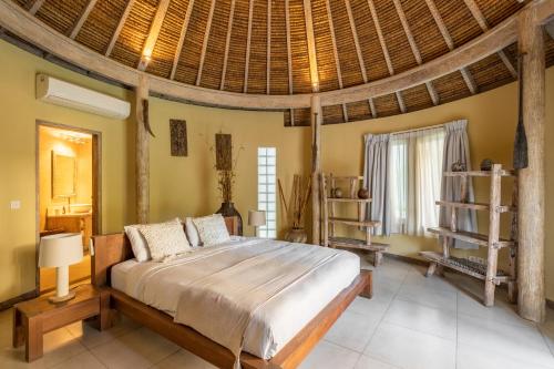 a bedroom with a large bed with a wooden ceiling at Spacious and Stylish Villa 3 Bedroom Seminyak in Denpasar