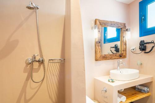 a bathroom with a sink and a shower with a mirror at Junior Traditional Suite in Archangelos