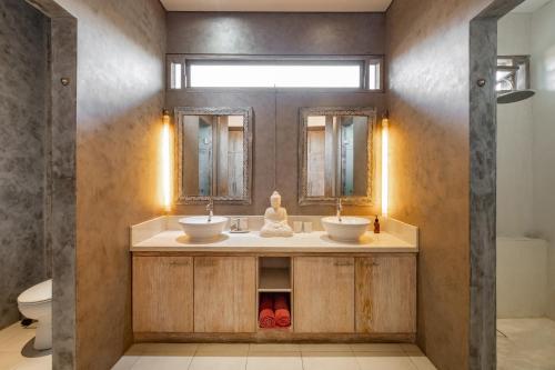 a bathroom with two sinks and a mirror at Spacious and Stylish Villa 3 Bedroom Seminyak in Denpasar