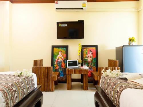 a room with two beds and a laptop on a table at AIRBEST Explore Chiang Rai Hotel in Chiang Rai