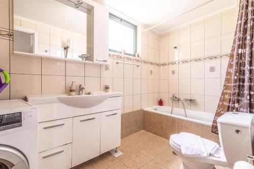 a bathroom with a sink and a toilet and a tub at House with Pool & Garden for Families & Friends 2 in Heraklio Town