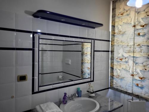 La salle de bains est pourvue d'un lavabo et d'un grand miroir. dans l'établissement COLLINA FIORITA, à Tollo