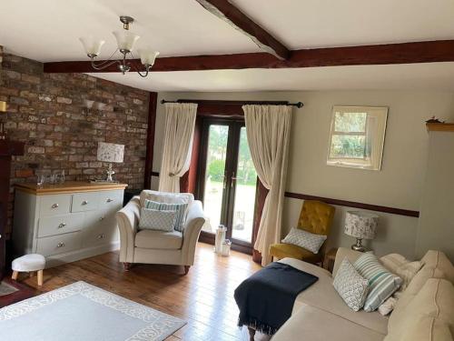 a living room with a couch and chairs and a window at Rural Family Farmhouse with Countryside views in Southport