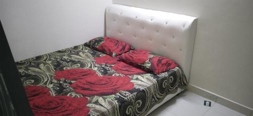 un letto con rose rosse sopra in una stanza di Homestay Merbau Bandar Putra Kulai a Kulai
