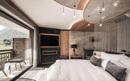 a bedroom with a large bed and a balcony at Hotel Wagnerhof in Pertisau
