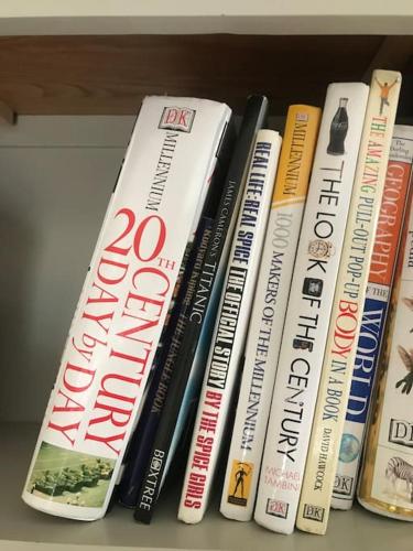 a group of books sitting on a shelf at Rural Family Farmhouse with Countryside views in Southport