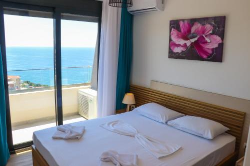 a bedroom with a bed and a large window at Eagles Apartments & Suites in Ulcinj