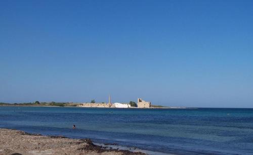 a body of water with a small island in the distance at Hotel Villa Ionia in Avola