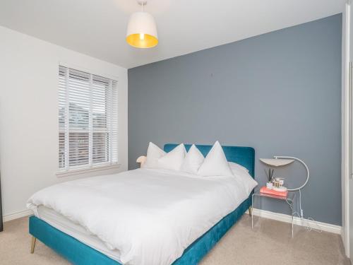 a bedroom with a blue and white bed and a window at Cosy Modern Flat Pass The Keys in Edinburgh