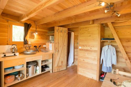 una cocina en una cabaña de madera con paredes de madera en Huttopia Pays de Cordes sur Ciel, en Albi