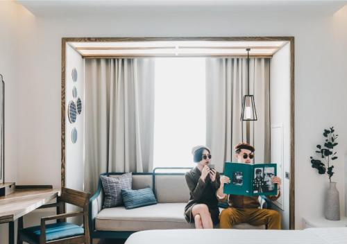 two people sitting on a couch in a room at SYN Boutique Hotel in Chiang Mai