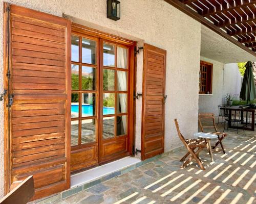 eine Holztür eines Hauses mit einer Terrasse in der Unterkunft George's gorgeous house Anavysos in Anavyssos