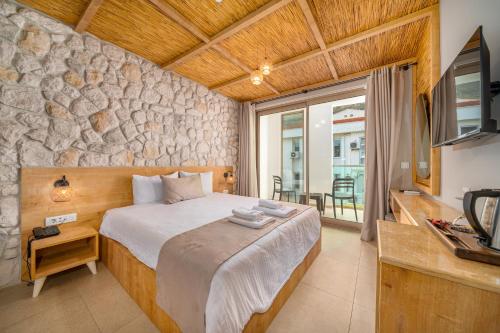 a bedroom with a bed with a stone wall at Melisa Boutique Hotel & Spa in Kaş