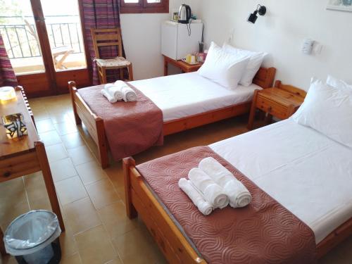 a room with two beds with towels on them at Loggia Two in Agia Galini