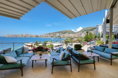 a patio with blue furniture and a view of the water at Hotel Saranda Butrinti, Affiliated by Melia in Sarandë