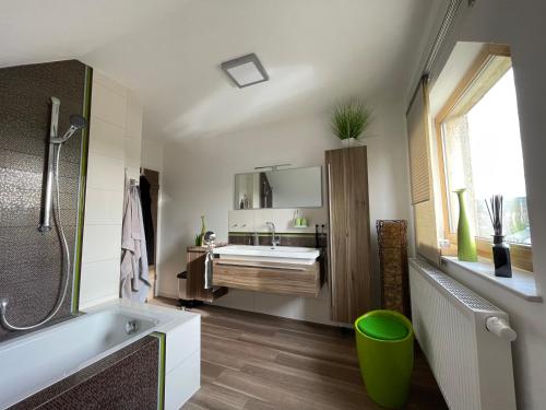 een badkamer met een bad, een wastafel en een bad bij Einzigartiges Haus mit Pool großem Garten und Kamin in Bad Salzungen