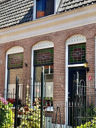 un edificio de ladrillo con una puerta y ventanas negras en Tiziana's Herberg, en Zierikzee