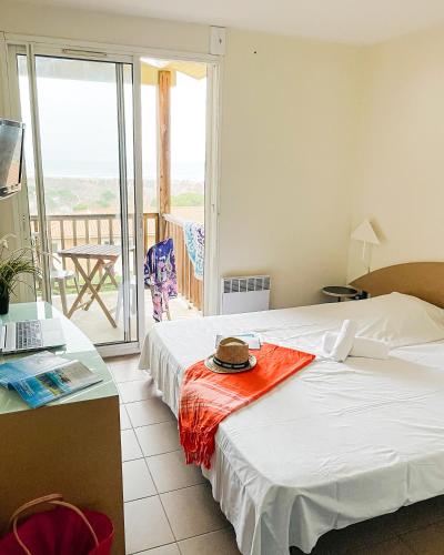 une chambre d'hôtel avec un lit avec un chapeau dessus dans l'établissement VVF Narbonne-Plage Saint-Pierre-la-Mer, à Fleury