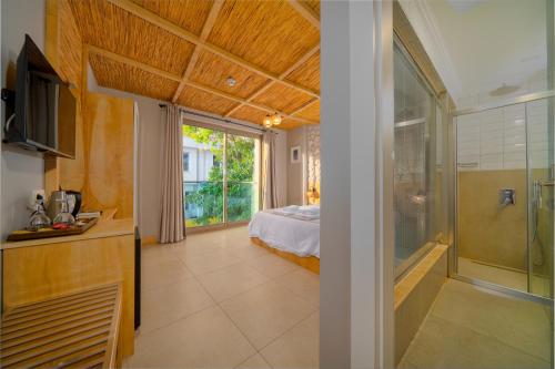 a bedroom with a bed and a glass shower at Melisa Boutique Hotel & Spa in Kaş
