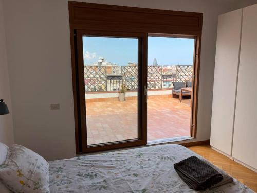 - une chambre avec un lit et une grande fenêtre dans l'établissement Terrazas y vistas en el centro, à Barcelone