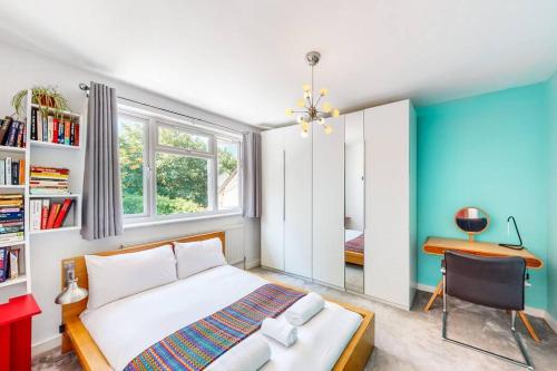 1 dormitorio con cama y escritorio. en Modernistic 2 BR maisonette in Kingsbury en Colindale