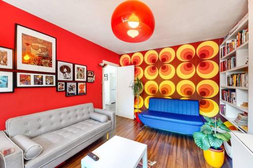 a living room with a couch and a colorful wall at Modernistic 2 BR maisonette in Kingsbury in Colindale