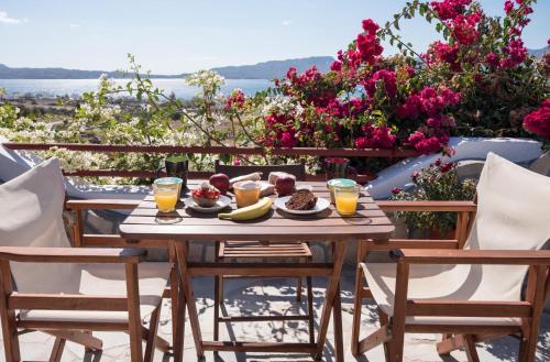 einen Tisch mit Speisen und Getränken auf einem Balkon mit Blumen in der Unterkunft Christos rooms milos in Adamas