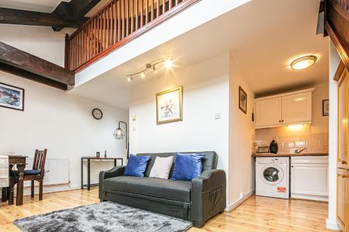 a living room with a couch and a kitchen at Beautiful 1-Bed Apartment in Grade Listed Warehouse - Victoria Quays, Sheffield City Centre, FREE Parking, Pet Friendly, Netflix in Sheffield