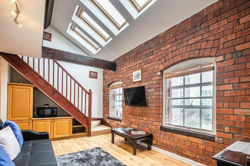 a living room with a brick wall at Beautiful 1-Bed Apartment in Grade Listed Warehouse - Victoria Quays, Sheffield City Centre, FREE Parking, Pet Friendly, Netflix in Sheffield