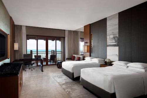 una camera d'albergo con 2 letti e una scrivania di Haikou Marriott Hotel a Haikou