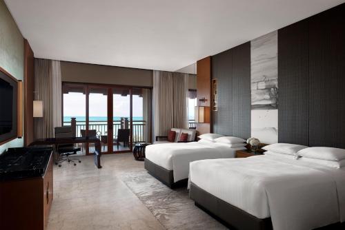 a hotel room with two beds and a desk at Haikou Marriott Hotel in Haikou