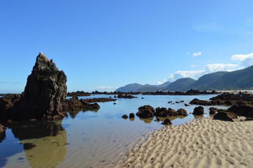 a view of a beach with rocks in the water at Apartamento El Olivo in Noja