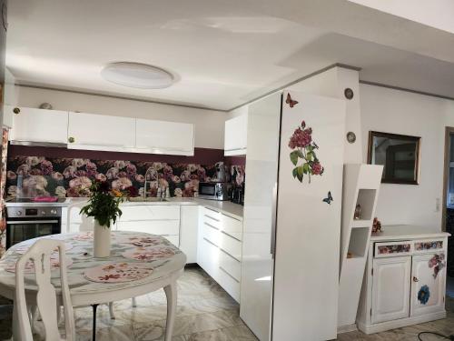 a kitchen with a table and a white refrigerator at Ferienhaus Ani in Patzig