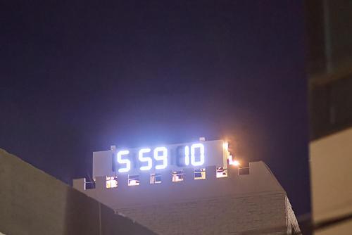 une horloge au-dessus d'un bâtiment la nuit dans l'établissement Aank Hotel Busan Nampo, à Busan