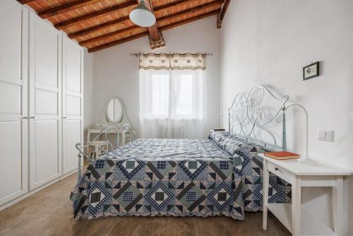 a bedroom with a bed and a table and a window at Anita in Colle di Val d'Elsa