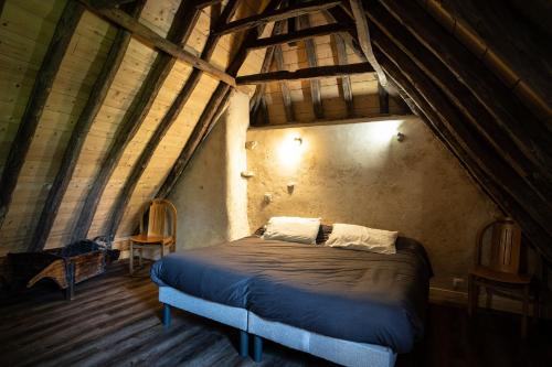 ein Schlafzimmer mit einem großen Bett im Dachgeschoss in der Unterkunft Les Terres Nères in Aucun