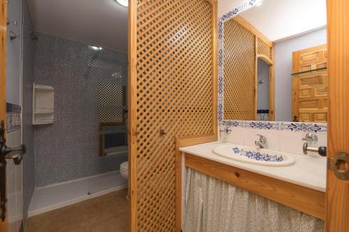 y baño con lavabo, ducha y espejo. en Corazon de Tarifa en Zahara de los Atunes