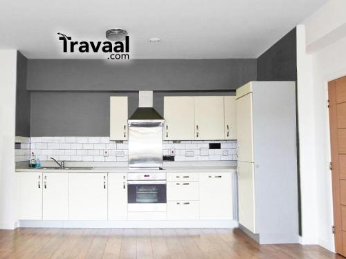 a kitchen with white cabinets and white appliances at Wallis Square in Farnborough