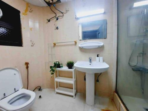 uma casa de banho com um lavatório e um WC em Master Bed Room with Balcony Shared Apartment AUH UAE em Abu Dhabi