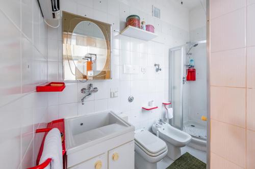 La salle de bains blanche est pourvue d'un lavabo et de toilettes. dans l'établissement Pescara Colli Roomy Apartment with parking, à Pescara