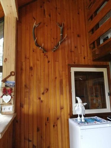une pièce avec un réfrigérateur et des bois de cerf sur un mur dans l'établissement haut de chalet le Bois de Cerf, aux Angles