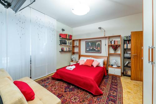 a bedroom with a red bed and a couch at Pescara Colli Roomy Apartment with parking in Pescara
