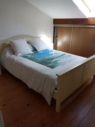 une chambre avec un grand lit avec des draps et des oreillers blancs dans l'établissement Villa climatisée proche mer Carnon Pérols, à Pérols