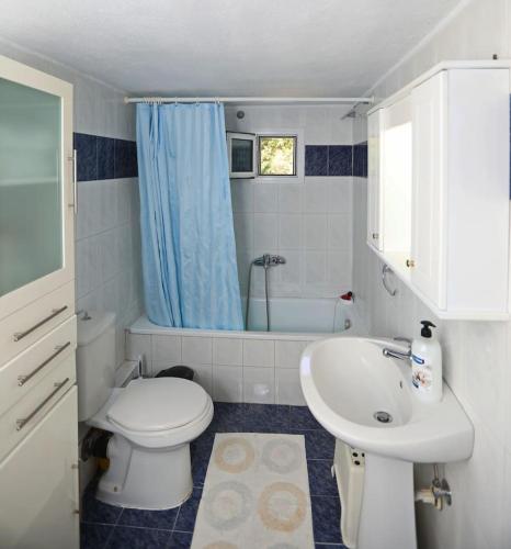a bathroom with a toilet and a sink and a tub at DIANA'S HOUSE in Khrisókastron