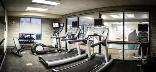 a gym with several tread machines and a pool at Courtyard by Marriott Norman in Norman