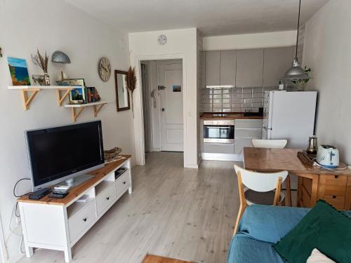 sala de estar con TV y cocina en Cozy apartment with pool close to beach & nature en L'Estartit